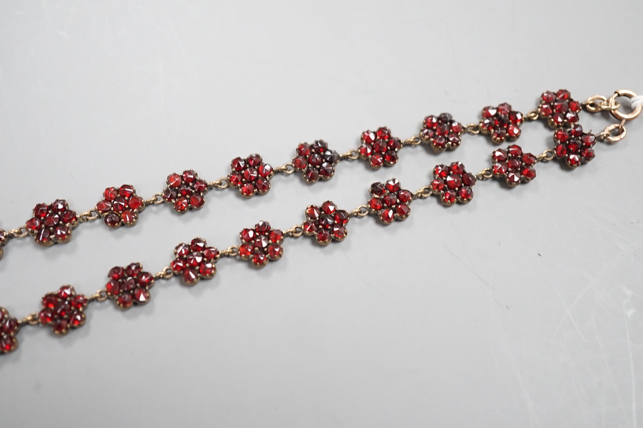 A late Victorian gilt and yellow metal, garnet cluster set drop necklace, 48cm.